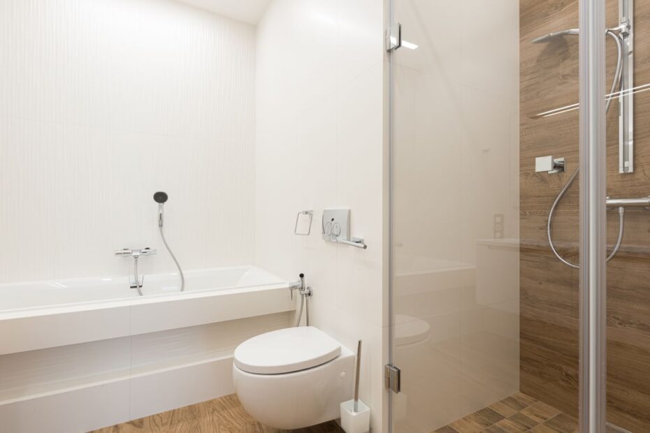 Salle de bain lumineuse avec toilettes, douche vitrée et baignoire